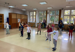 Dzieci tańczą z szarfami na zajęciach muzyczno-ruchowych w MDK